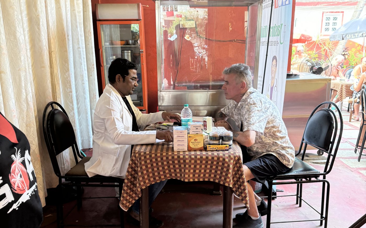 A doctor discussing an Ayurvedic care plan during a community consultation